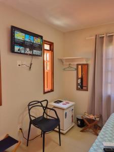a room with a chair and a stove and a window at Suíte na vila de Praia do Forte in Praia do Forte