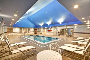 una gran piscina con sillas y un gran techo azul en TownePlace Suites by Marriott Dover Rockaway, en Dover