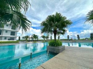 a swimming pool with a palm tree next to a building at Paradigm Mall Johor Bahru The Platino 3 Bedroom in Johor Bahru