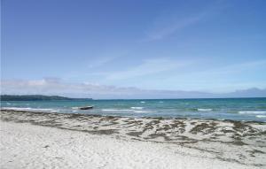 a sandy beach with a boat in the ocean at Cozy Home In Vig With Kitchen in Vig