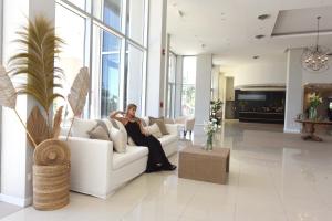 kobieta siedząca na kanapie w salonie w obiekcie Camberland Resort & Spa Ramallo w mieście Ramallo