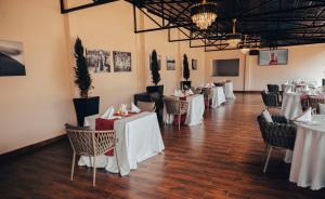 un comedor con mesas y sillas blancas en Madras Hotel and Apartments, en Kigali