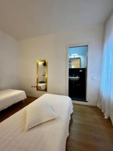 a white room with two beds and a mirror at I Limoni di Vernazza in Vernazza