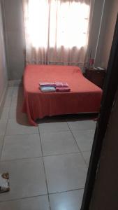 Schlafzimmer mit einem Bett mit roter Bettwäsche und einem Fenster in der Unterkunft Victoria apart in San Ramón de la Nueva Orán