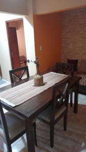 a wooden table with a vase on top of it at Victoria apart in San Ramón de la Nueva Orán +19 photos
