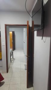 Habitación con pasillo con puerta y TV en Victoria apart, en San Ramón de la Nueva Orán