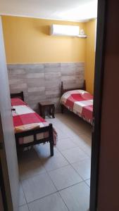 a room with two twin beds in a room at Victoria apart in San Ramón de la Nueva Orán