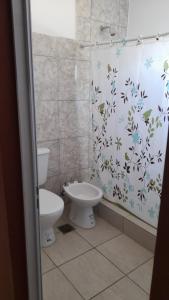 ein Bad mit einem WC und einem Duschvorhang in der Unterkunft Victoria apart in San Ramón de la Nueva Orán
