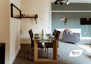 a dining room with a table with chairs and a couch at Luke Stays -Whitehall Road in Gateshead