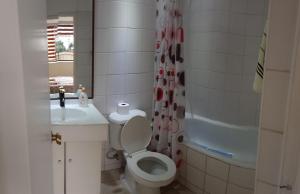 łazienka z toaletą, umywalką i wanną w obiekcie Departamento Centro Temuco 3D, 2B, Familiar, Piscina, Estacionamiento w mieście Temuco