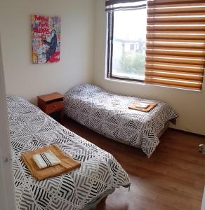 a room with two beds and a window at Departamento Centro Temuco 3D, 2B, Familiar, Piscina, Estacionamiento in Temuco