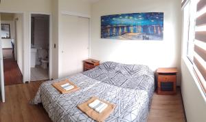 a bedroom with a bed and a painting on the wall at Departamento Centro Temuco 3D, 2B, Familiar, Piscina, Estacionamiento in Temuco