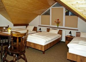 sypialnia z 2 łóżkami, stołem i oknem w obiekcie Noclegi Helvet w mieście Ustrzyki Dolne