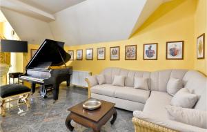 a living room with a couch and a piano at Lovely Home In Sv,kriz Zacretje With Sauna in Gornja Pačetina