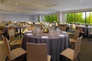 una sala de conferencias con mesas y sillas con gafas. en Four Points by Sheraton Warsaw Mokotow, en Varsovia