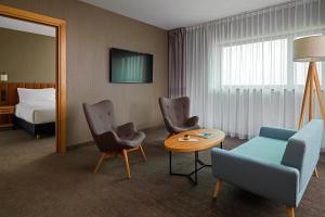 Habitación de hotel con cama, mesa y sillas en Four Points by Sheraton Warsaw Mokotow, en Varsovia