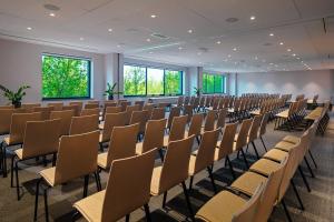 an empty room with rows of chairs in it at Four Points by Sheraton Warsaw Mokotow in Warsaw