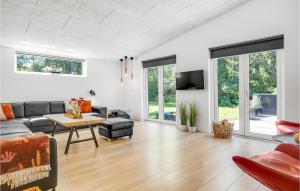 エーベルトフトにあるStunning Home In Ebeltoft With 6 Bedrooms And Wifiのリビングルーム(ソファ、テーブル付)