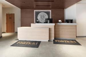 Stony CreekにあるFairfield Inn & Suites by Marriott Stony Creekの壁にリズミア2本が付いたフロントデスクのあるオフィス