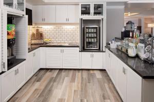 a kitchen with white cabinets and a wooden floor at Residence Inn by Marriott Tysons in Tysons Corner
