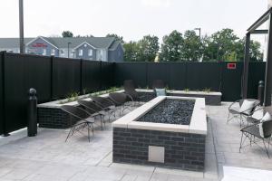 a patio with chairs and a pool with a fence at Courtyard Elkhart in Elkhart