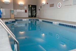 uma grande piscina com água azul num quarto em Courtyard Elkhart em Elkhart
