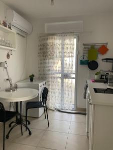 een keuken met een tafel, een wastafel en een raam bij my holiday apartment in Zikhron Ya‘aqov