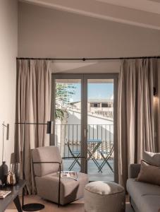 een woonkamer met een glazen schuifdeur naar een balkon bij Can Verí Suites in Sóller