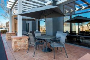 a patio with a table and chairs and umbrellas at Fairfield Inn & Suites by Marriott Santa Fe in Santa Fe