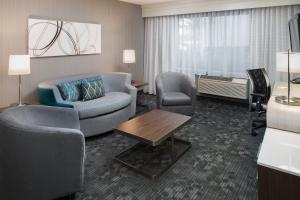 a hotel room with a couch and chairs and a table at Courtyard by Marriott Vacaville in Vacaville