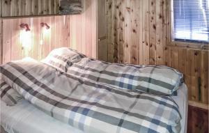a bed in a room with wood paneling at Amazing Home In Rros With 3 Bedrooms in Røros