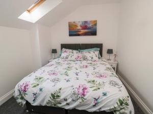 a bedroom with a bed with a floral bedspread at Lavenna in Alnwick