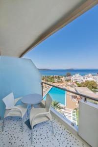 een balkon met een tafel en stoelen en uitzicht op de oceaan bij Marmari Bay Hotel in Marmarion