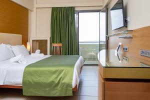 マルマリにあるMarmari Bay Hotelのベッドと大きな窓が備わるホテルルームです。