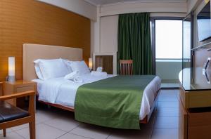 マルマリにあるMarmari Bay Hotelのベッドとテレビが備わるホテルルームです。