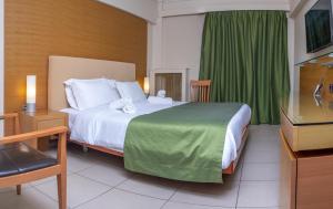 a bedroom with a large bed with a green curtain at Marmari Bay Hotel in Marmarion