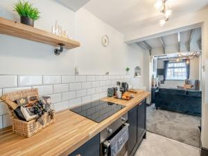 a kitchen with a counter top and a living room at The Tipsy Bee At 143, in Guisborough
