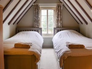two twin beds in a room with a window at The Coach House in Lusby