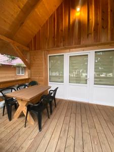 a wooden deck with a wooden table and chairs at Ranczo Targówka in Malanów