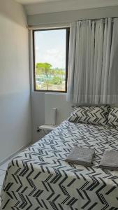 Un dormitorio con una cama grande y una ventana en Lindo Apartamento com piscina à 100m do MAR, en Recife