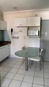 cocina con mesa verde y nevera en Lindo Apartamento com piscina à 100m do MAR, en Recife