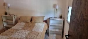 1 dormitorio pequeño con 1 cama y 2 mesitas de noche en Departamento Costa Paz en Villa Carlos Paz