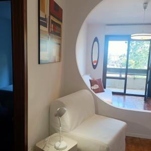 sala de estar con silla blanca y espejo en Appartamento Velocipede en Cervignano del Friuli