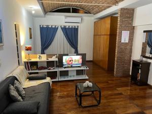 sala de estar con sofá y TV en Departamento tipo Loft en Balvanera en Buenos Aires
