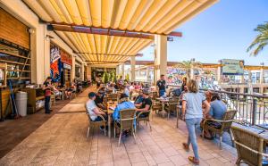 a group of people sitting at tables in a restaurant at Torri apartments - 3 mins walk to beach in Torrevieja