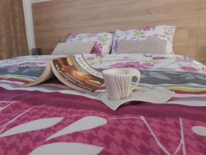 a bed with a book and a cup on it at Apartman Cristal LUX in Trebinje +7 photos
