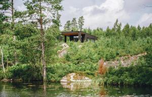 una casa en una colina junto a un cuerpo de agua en Awesome Home In Holmsj With Kitchen en Holmsjö