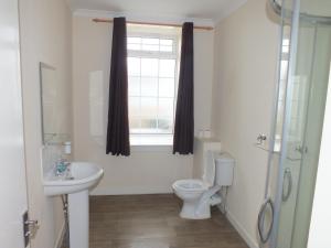 a bathroom with a toilet and a sink and a window at Marina Inn in Irvine