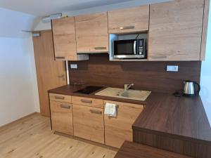 a kitchen with a sink and a microwave at Penzion Richard in Bělá pod Pradědem