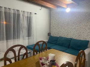 sala de estar con mesa y sofá azul en Cassanova I en San Luis
